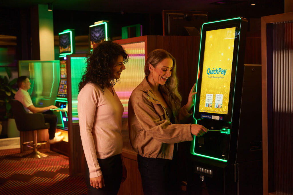 Patron on the gaming floor of an Australian venue using QuickPay Cash Redemption Terminal, monitored by the UTOPIA Global Gaming System.